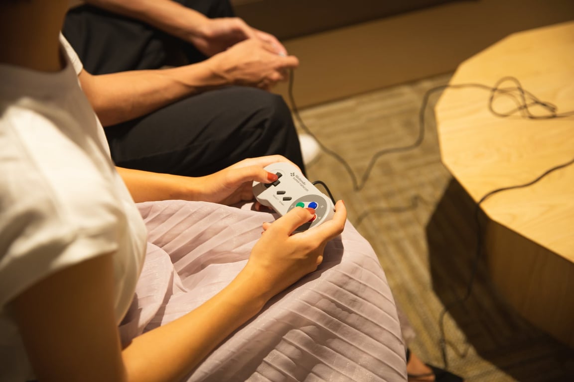 Couple méconnaissable jouant à un jeu vidéo avec des manettes de jeu à la maison